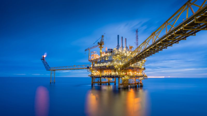 Offshore oil and gas central processing platform in sun set which produce raw gas, crude and hydrocarbon then sent to onshore refine, petrochemical industry. Power and energy business.