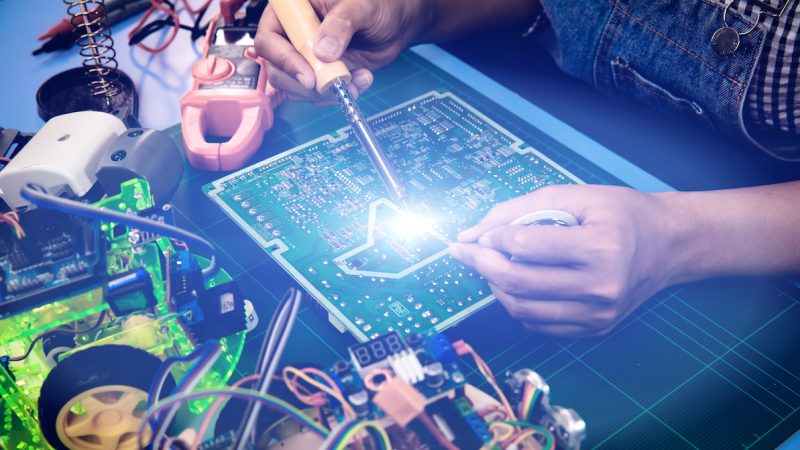 Engineer or Technician hand repair and assembly Electronic circuit board for veihcle robot with light effect, assembly control board by Soldering gun and solder