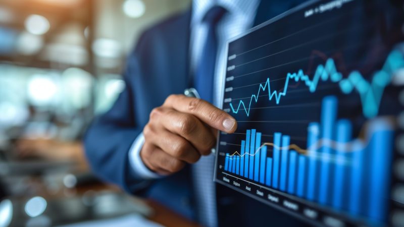 Businessman analyzing investment charts on virtual screen. Business and financial concept.