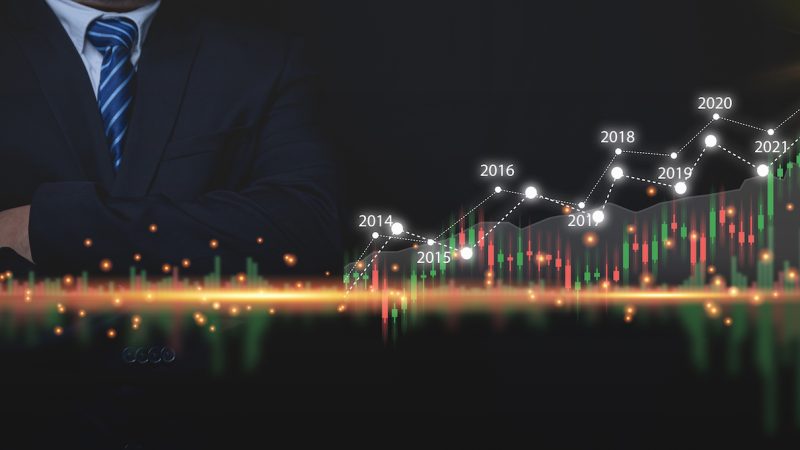 Business growth charts graph, finance, stock trading, investment analysis and stock market analysis. Businessman wearing a suit with his arms crossed with business growth graph market analysis.