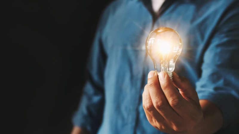 businessman hand holding lightbulb. idea Alternative energy concept saving electricity